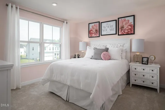 a bedroom with a bed and a lamp on dresser