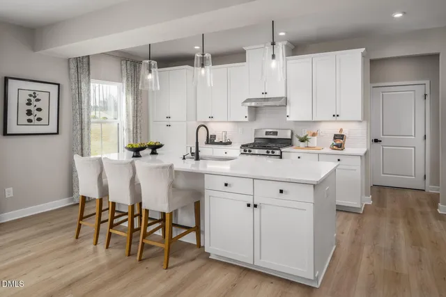 a kitchen with stainless steel appliances white cabinets and wooden floor