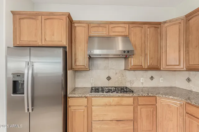 a kitchen with granite countertop a sink a window and cabinets