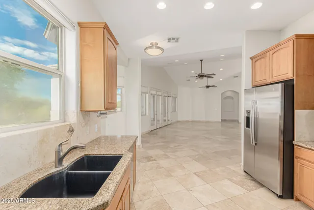 a view of kitchen with granite countertop cabinets and sink