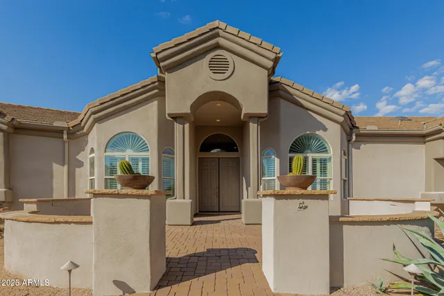 a view of a big house with a fountain