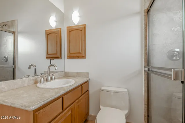 a bathroom with a sink toilet double vanity and shower