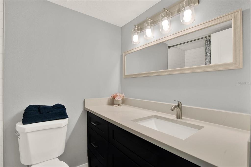 337 Rex Place, Unit A Madeira Beach, FL 33708 - Photo 19 of 48 a bathroom with a sink a toilet and a mirror