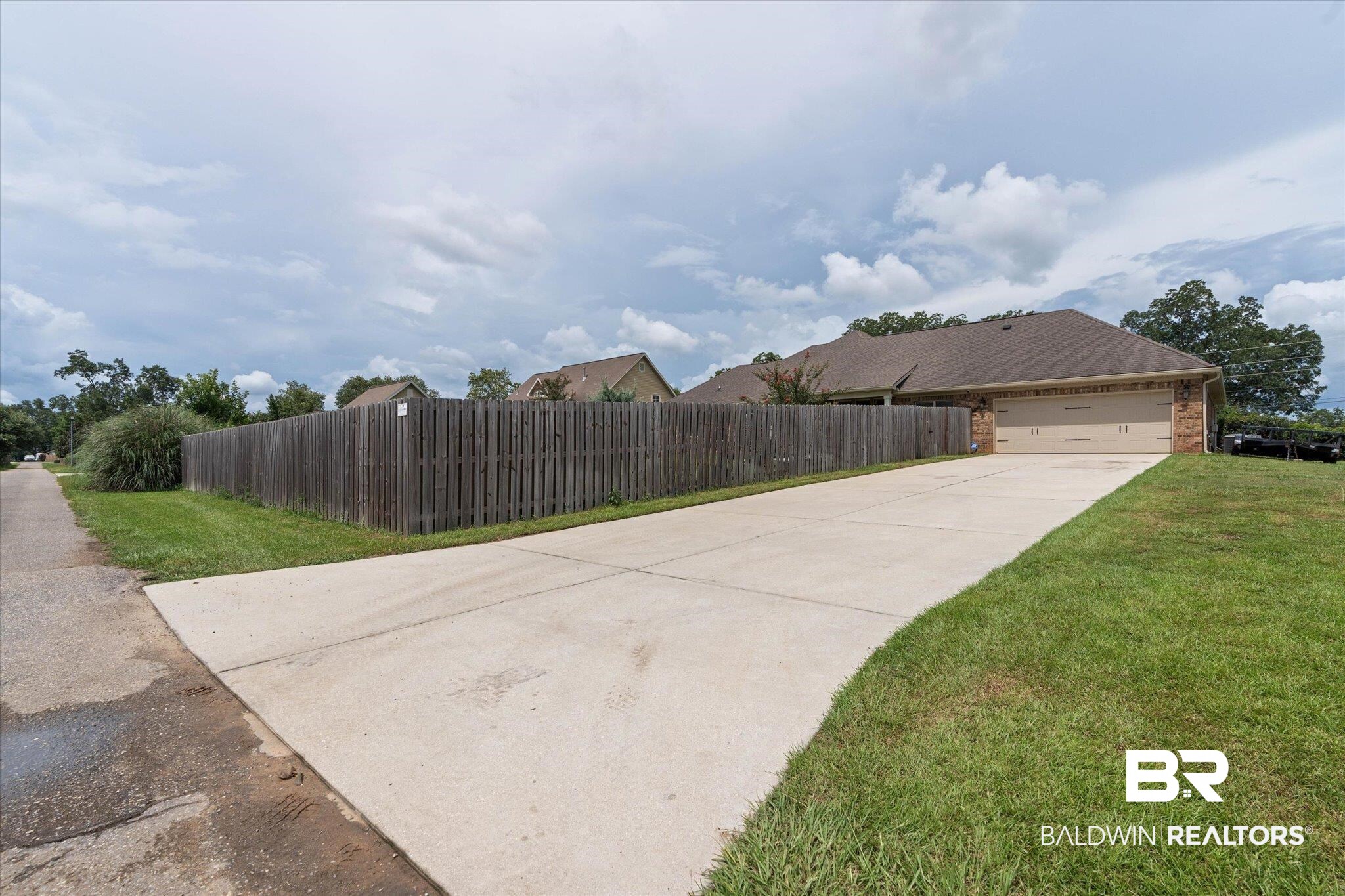 24821 Austin Road Daphne, AL 36526 - Photo 20 of 24 View of side of home featuring concrete driveway, brick siding, and an attached garage