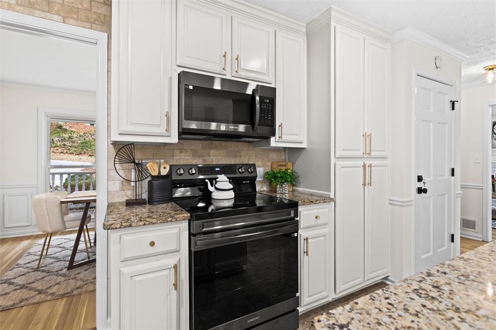 1101 Steeple Run Lawrenceville, GA 30043 - Photo 22 of 70 a kitchen with stainless steel appliances granite countertop a stove a microwave and cabinets