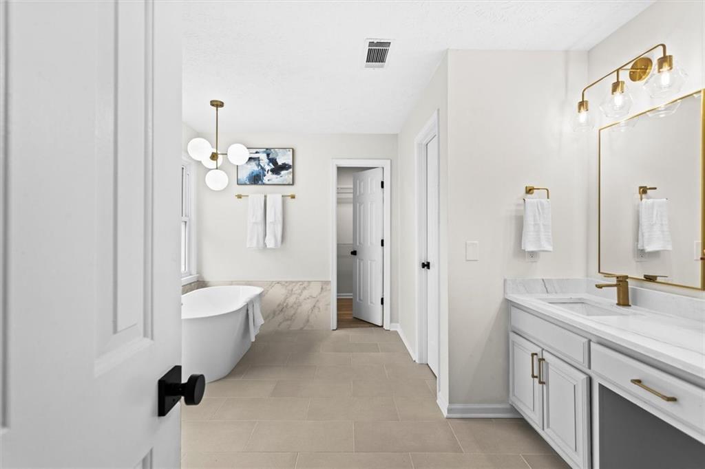 1101 Steeple Run Lawrenceville, GA 30043 - Photo 42 of 70 a bathroom with a double vanity sink a mirror a bathtub and shower