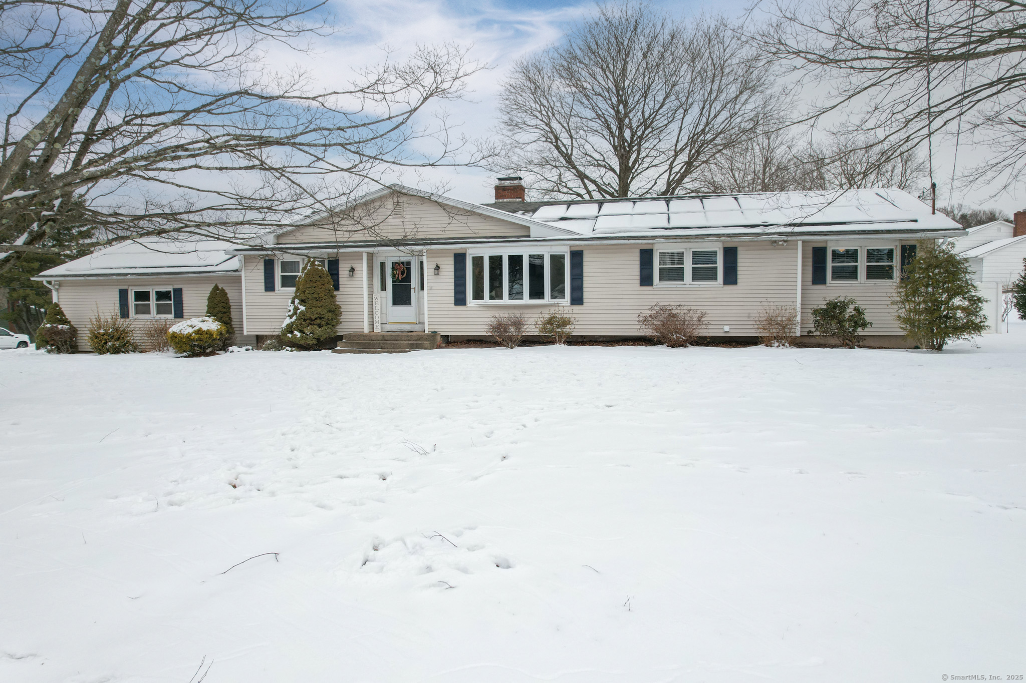 a front view of a house with a yard covered in snow