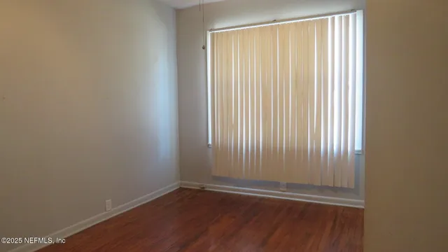 a view of wooden floor and window in a room