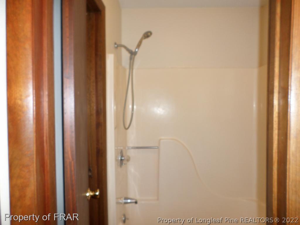 6712 Vaughn Road Fayetteville, NC 28304 - Photo 12 of 19 a bathroom with a glass shower door
