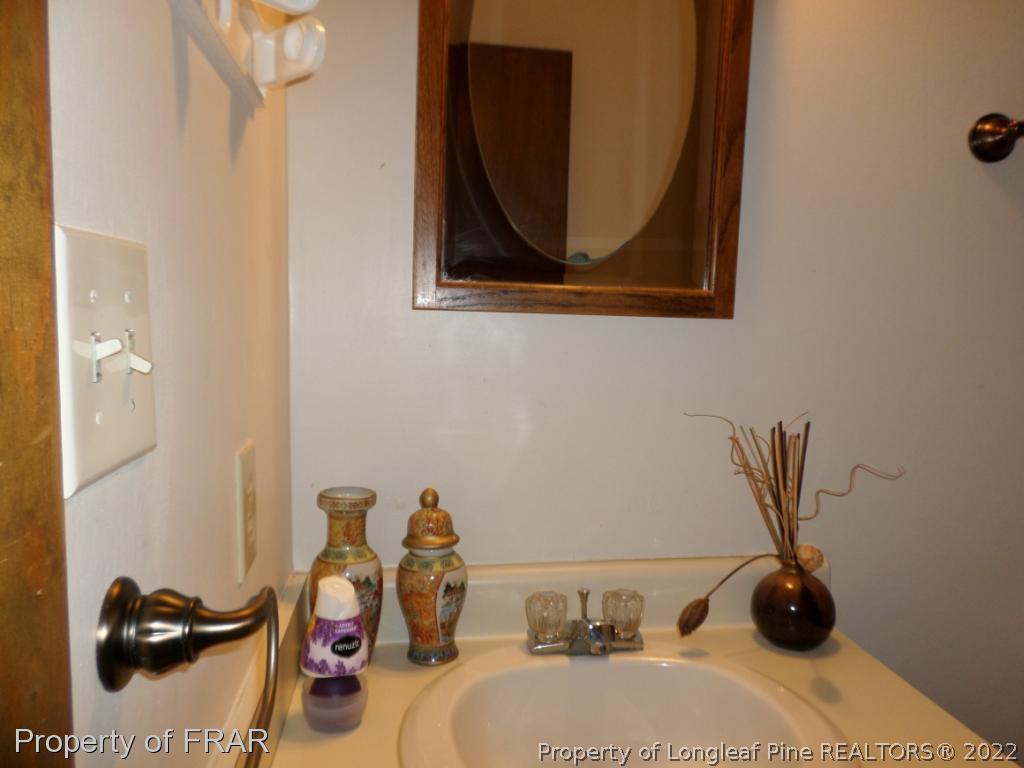 6712 Vaughn Road Fayetteville, NC 28304 - Photo 14 of 19 a bathroom with a sink and a mirror