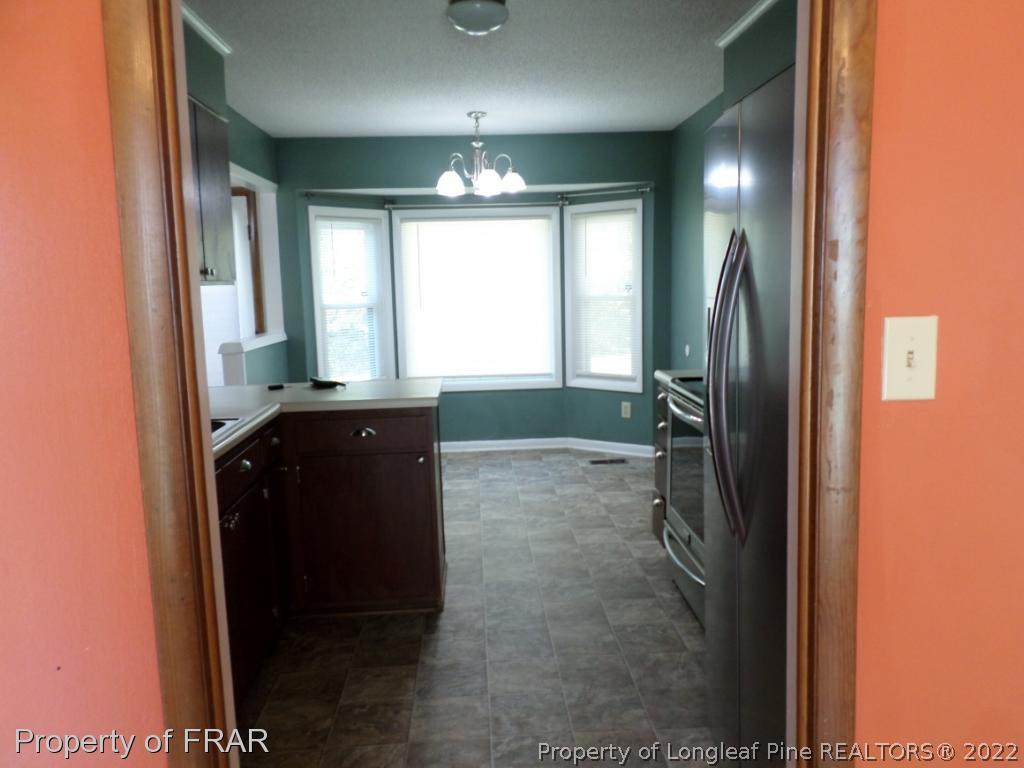 6712 Vaughn Road Fayetteville, NC 28304 - Photo 6 of 19 a view of a hallway and a livingroom with a chandelier