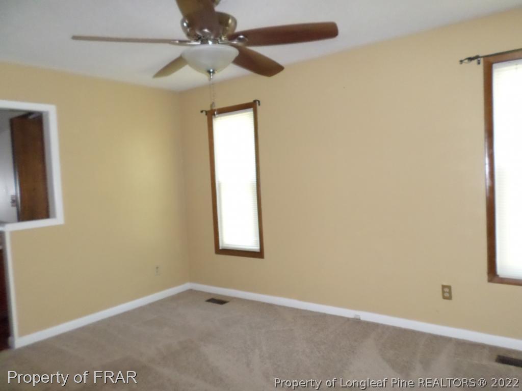 6712 Vaughn Road Fayetteville, NC 28304 - Photo 10 of 19 an empty room with windows and fan
