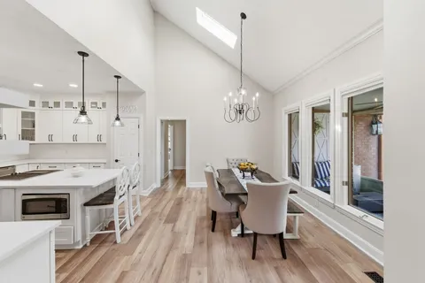 a view of a dining room with furniture a chandelier and wooden floor