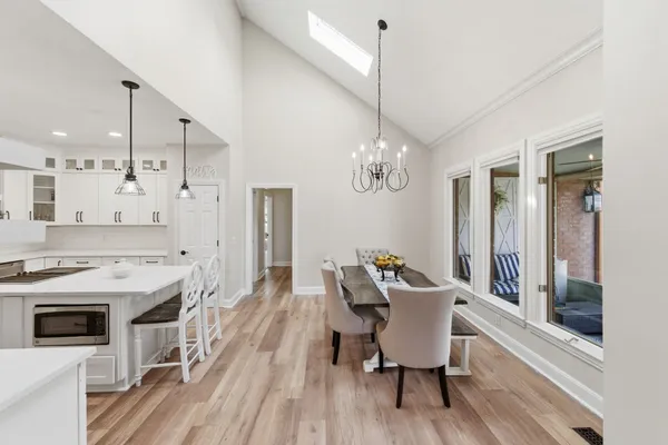 a view of a dining room with furniture a chandelier and wooden floor