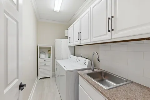 a utility room with sink dryer and washer