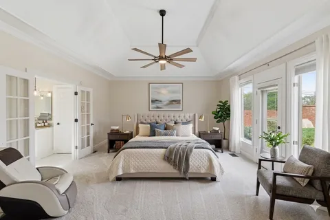 a bedroom with a bed couch and a large window