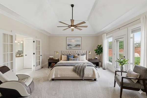 a bedroom with a bed couch and a large window