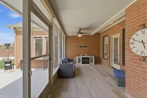 a view of a hallway with wooden floor and furniture
