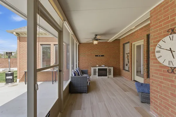 a view of a hallway with wooden floor and furniture
