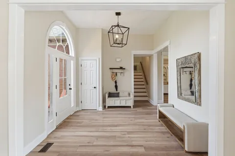 a hallway with wooden floor windows and entryway