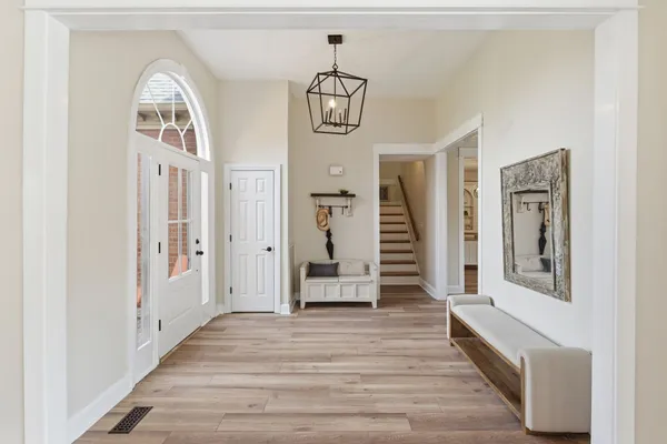 a hallway with wooden floor windows and entryway