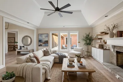 a living room with furniture fireplace and a large window