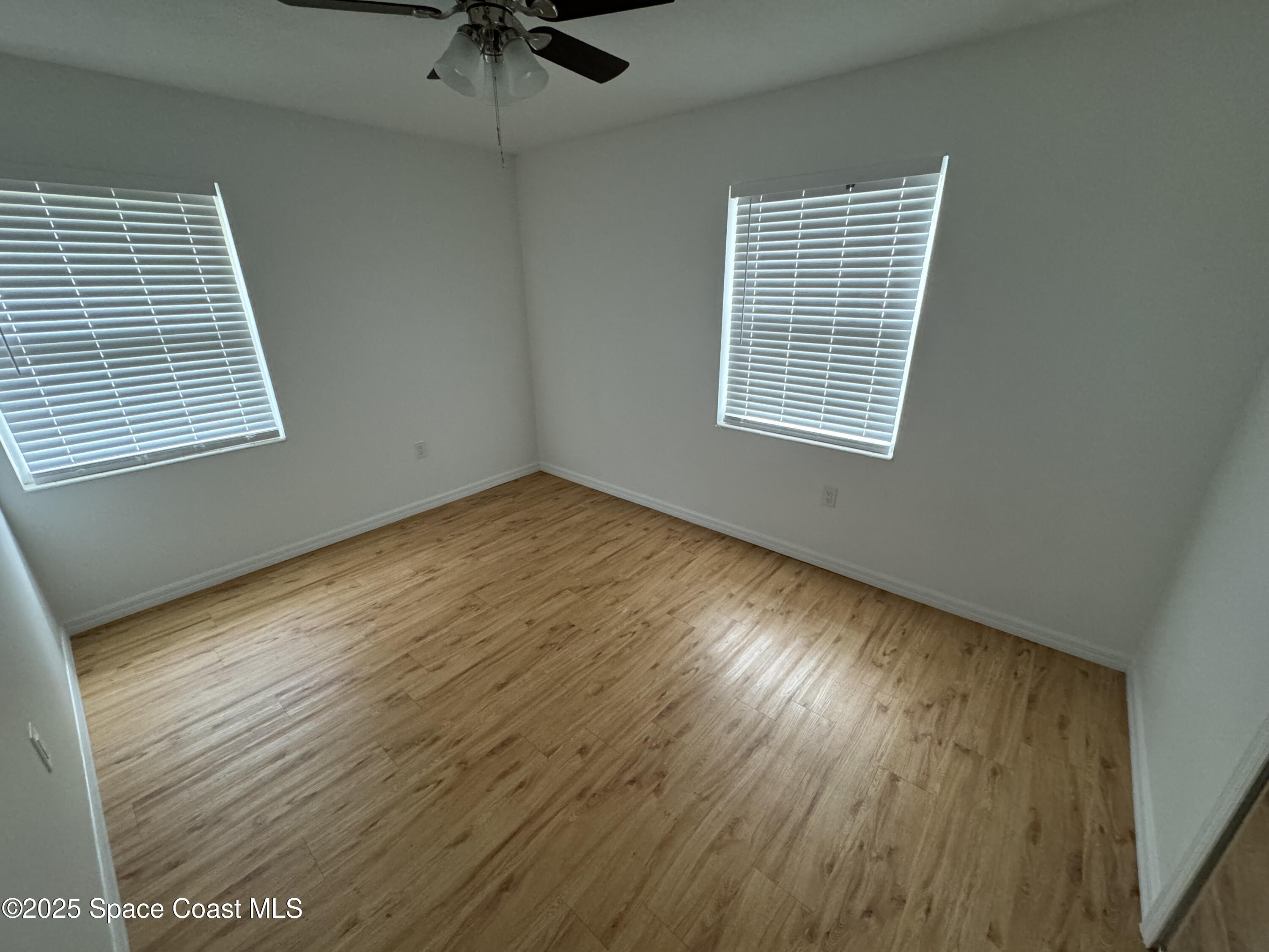 34 East Azalea Circle Rockledge, FL 32955 - Photo 7 of 11 a view of an empty room with wooden floor and a window