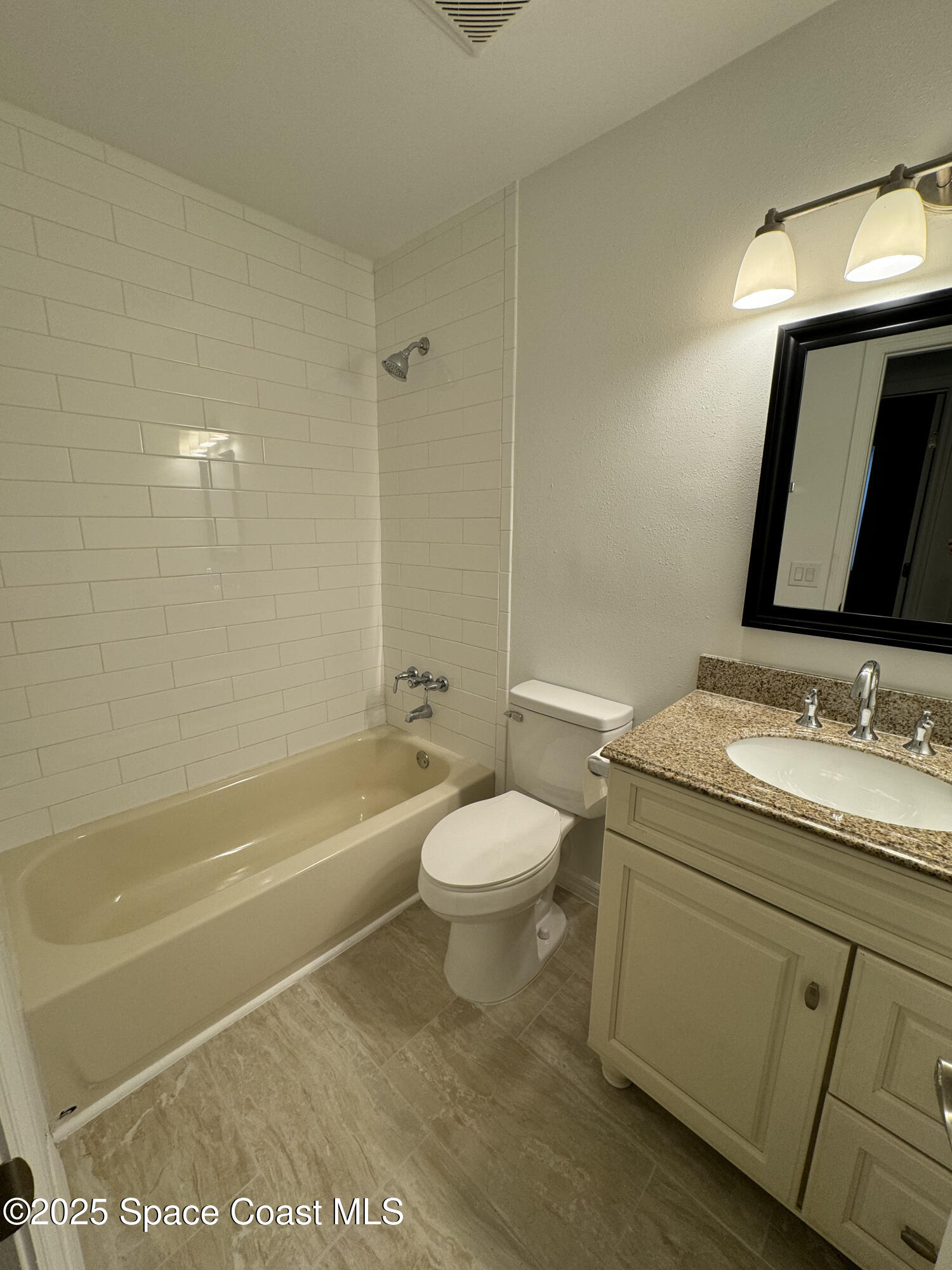 34 East Azalea Circle Rockledge, FL 32955 - Photo 10 of 11 a bathroom with a granite countertop toilet a sink and bathtub