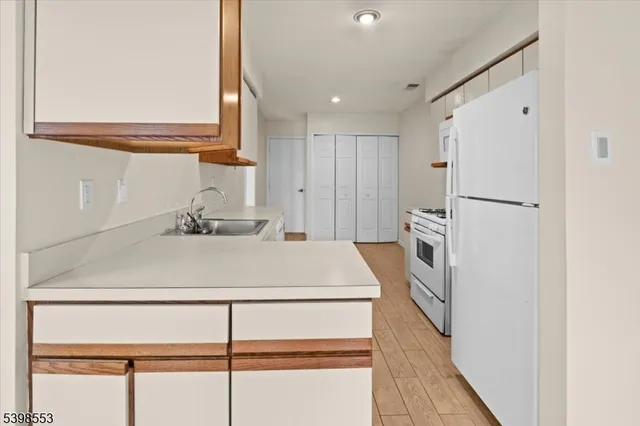 a kitchen with a refrigerator sink and cabinets