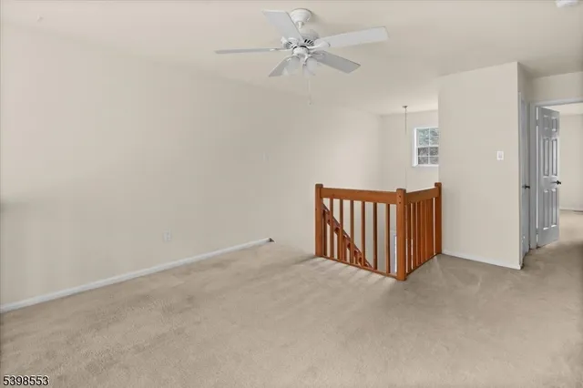 an empty room with a ceiling fan and a window