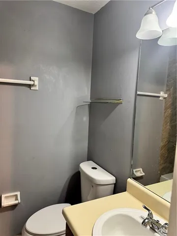 a white toilet sitting next to a bathroom sink and a shower