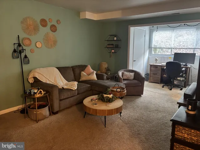 a living room with furniture a flat screen tv and a window
