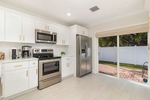 a kitchen with stainless steel appliances granite countertop a refrigerator a stove a microwave oven with a sink and dishwasher