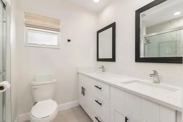 a bathroom with a toilet a sink a vanity and mirror