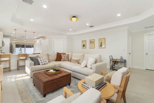 a living room with furniture and a view of kitchen