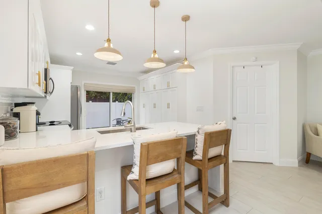 a kitchen with a dining table chairs and cabinets