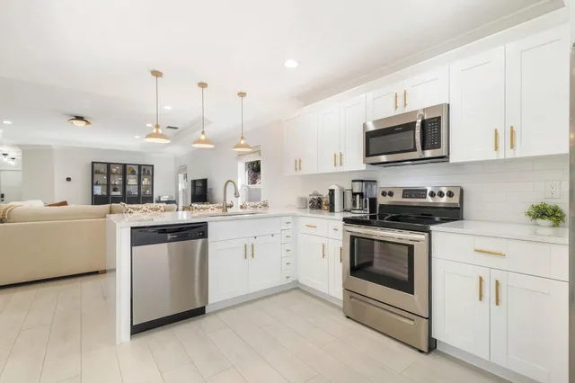 a kitchen with white cabinets stainless steel appliances and sink