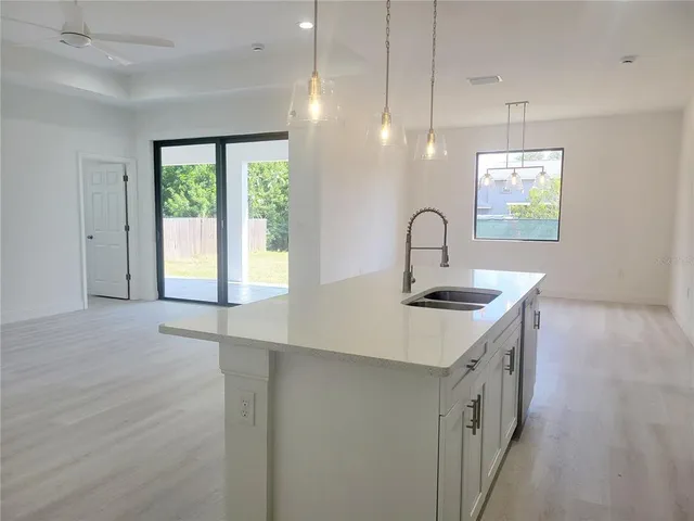 a kitchen with a sink a counter space and a dining table