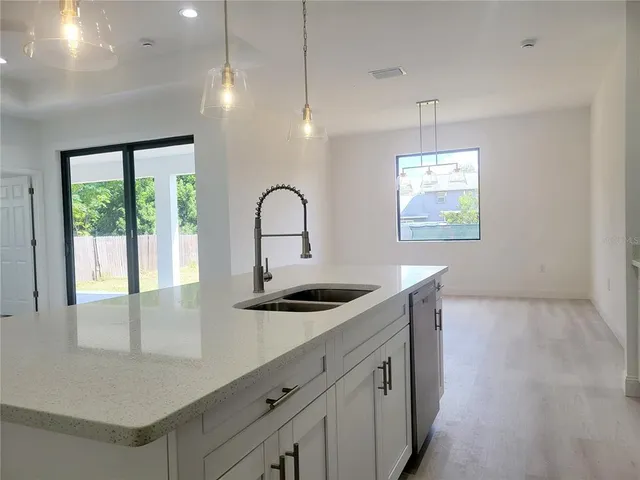 a kitchen with stainless steel appliances a sink and a hard wood floor