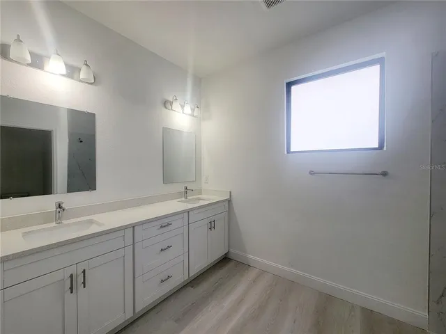 a bathroom with a double vanity sink and mirror