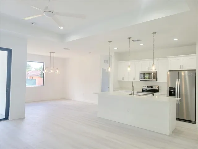 a kitchen with refrigerator cabinets and wooden floor