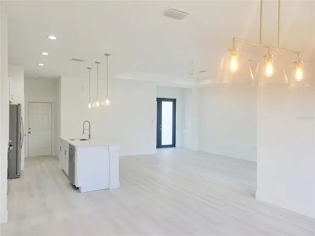 a view of an empty room with a kitchen