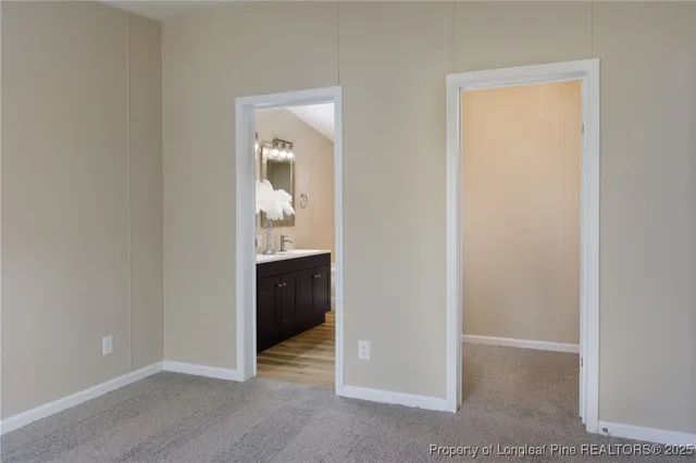 an empty room with mirror and a sink