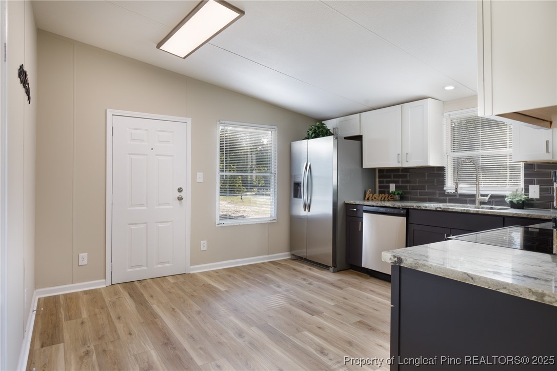 212 Heflin Road Aberdeen, NC 28315 - Photo 5 of 23 a kitchen with granite countertop white cabinets and stainless steel appliances