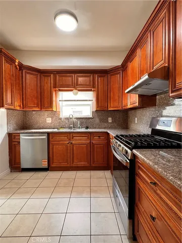 a kitchen with granite countertop a stove top oven sink and cabinets