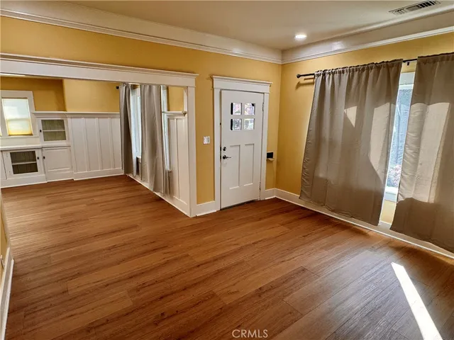 a view of empty room with wooden floor and window