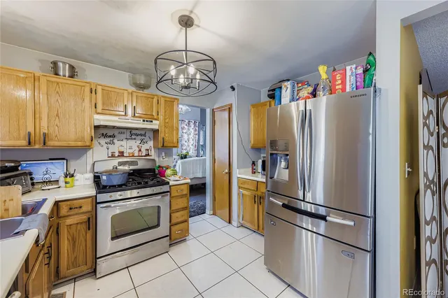 a kitchen with stainless steel appliances a refrigerator a stove a sink dishwasher and a refrigerator with wooden floor