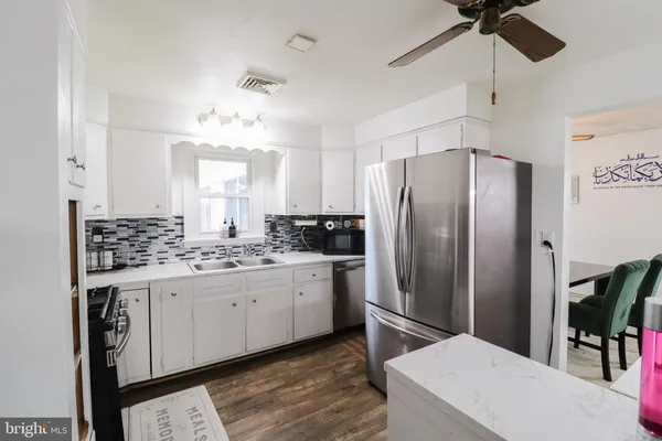 a kitchen with a refrigerator sink and cabinets