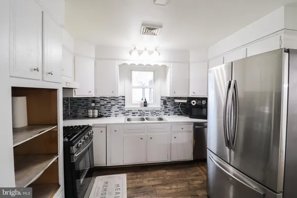 a kitchen with a sink stove top oven and cabinets