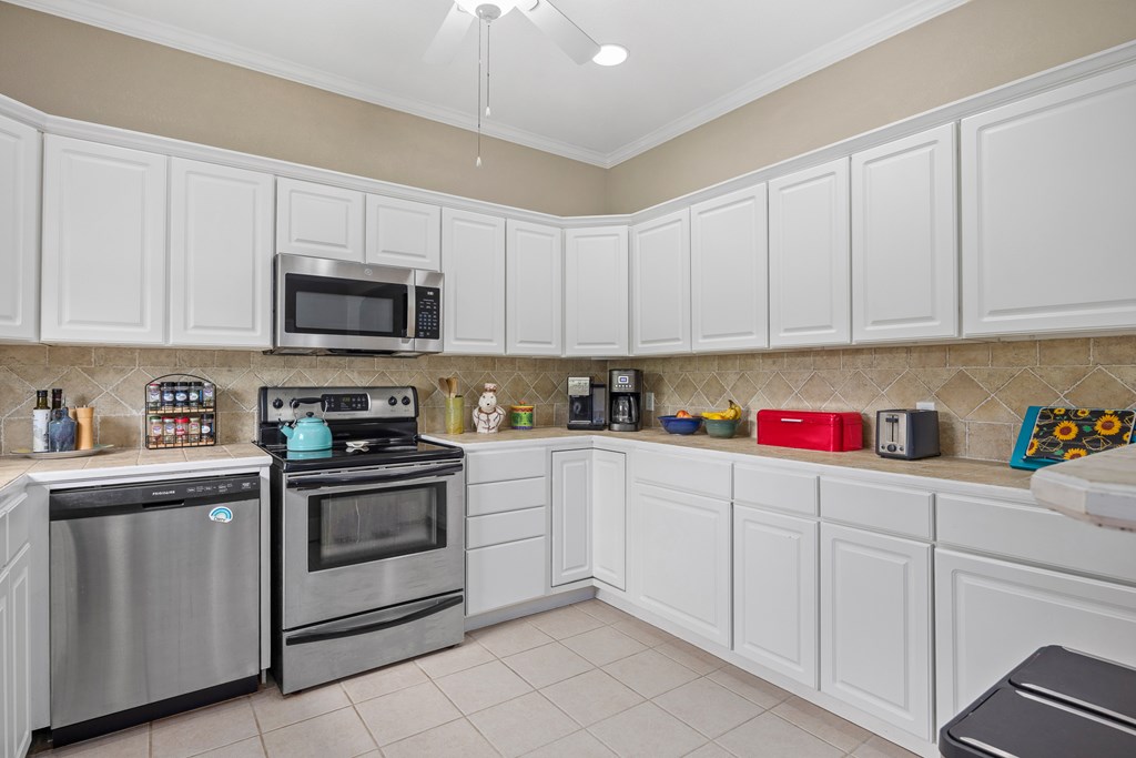 659 Town Creek Road Kerrville, TX 78028 - Photo 11 of 65 a kitchen with granite countertop white cabinets sink and stainless steel appliances